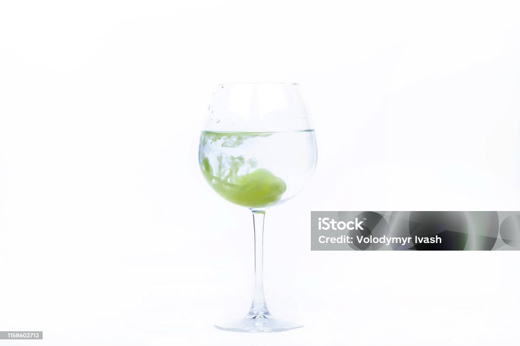 Yellow paint falls in a wineglass with water Advertisement Stock Photo