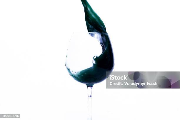 Green And Violet Water Splashes In A Wineglass Stock Photo - Download Image Now - Advertisement, Blue, Celebration