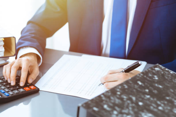 istock Bookkeeper or financial inspector hands making report, calculating or checking balance. Internal Revenue Service inspector man checking financial document. Business, tax and audit concepts. 1158603086