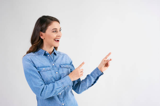 istock Happy woman showing at copy space in studio shot 1158604426