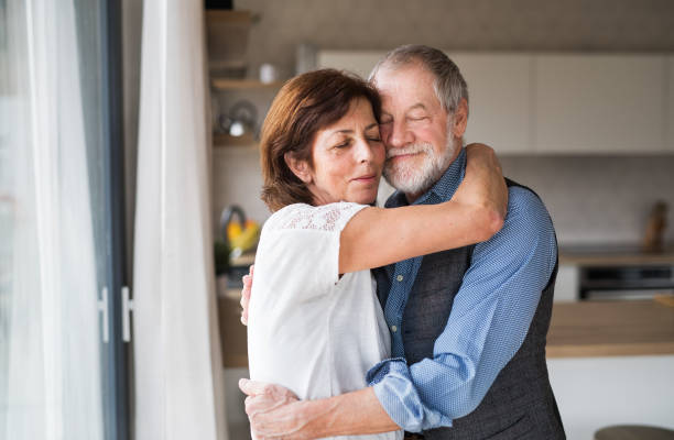 istock Affectionate senior couple in love standing indoors at home, hugging. 1158605625