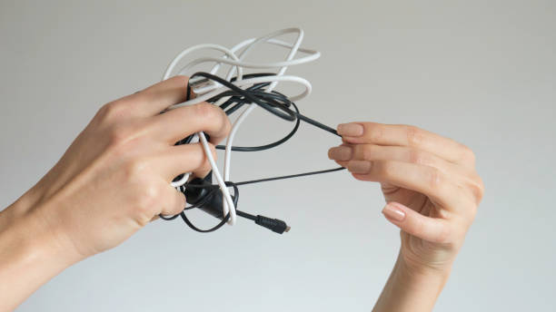 istock Black and white cables in a woman's hand on isolated background 1158605655