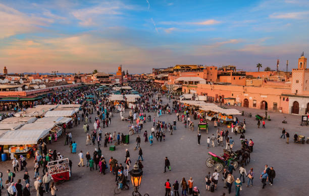 quadrado da noite djemaa el fna com mesquita de koutoubia, marrakech, marrocos, norte da áfrica - jema el fna - fotografias e filmes do acervo