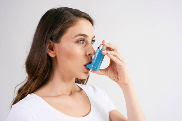 喘息発作時に喘息吸入器を使用した喘息女性 - asthmatic ストックフォトと画像
