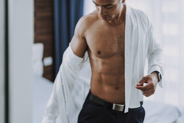 istock Attractive shapely man is putting on elegant clothes 1158607881