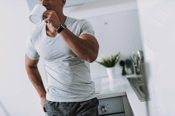 istock Athletic man is drinking morning coffee in kitchen 1158607888