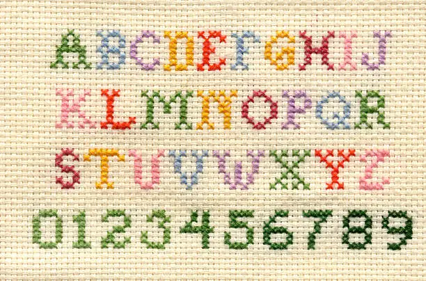 Upper case alphabet and numbers in cross stitch.