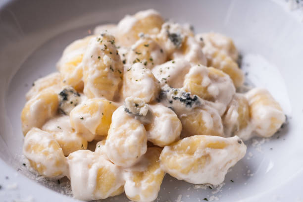 Gnocchi in white bechamel sauce with blue cheese stock photo