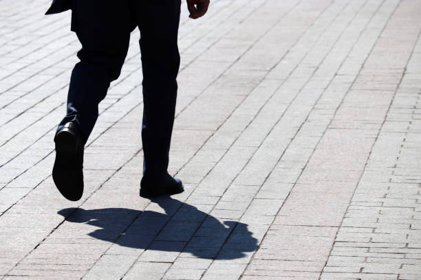 istock Silhouette and shadow of man walking down the street 1158609832