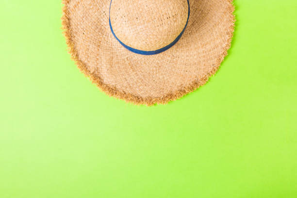 istock yellow retro straw hat top view with copy space. summer concept on green background 1158611454