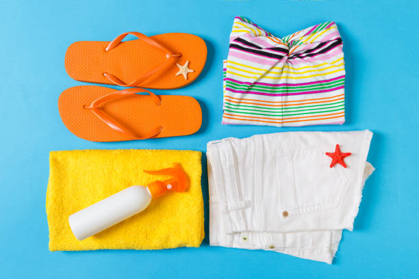 Flat lay composition with Beach accessories on blue color background. Summer holiday background. Vacation and travel items top view