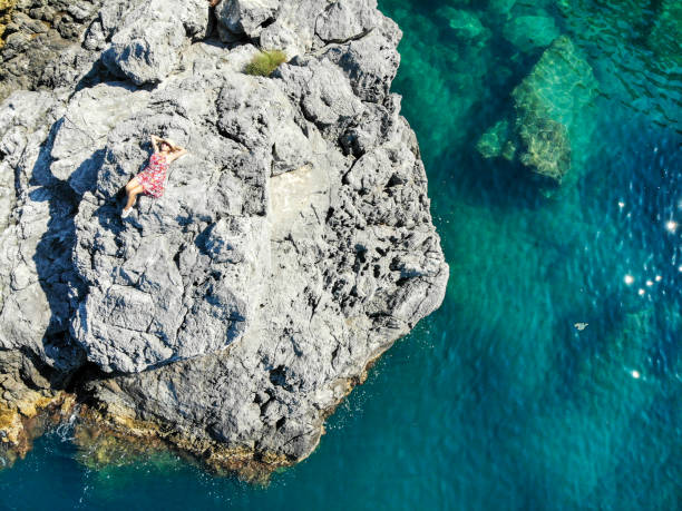 created by dji cameraWoman looking at see on cliffs.