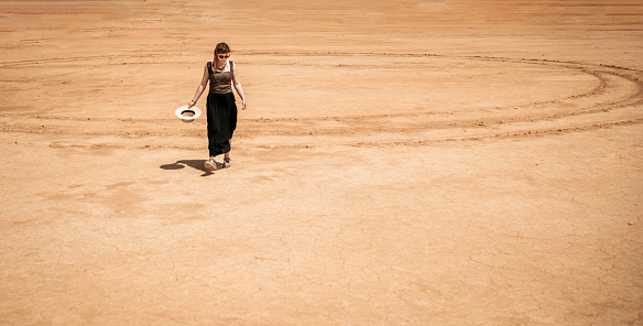 Young tourist woman walking through the desert