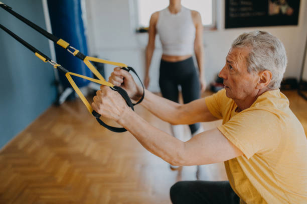 istock Senior man exercising with his personal trainer 1158618475
