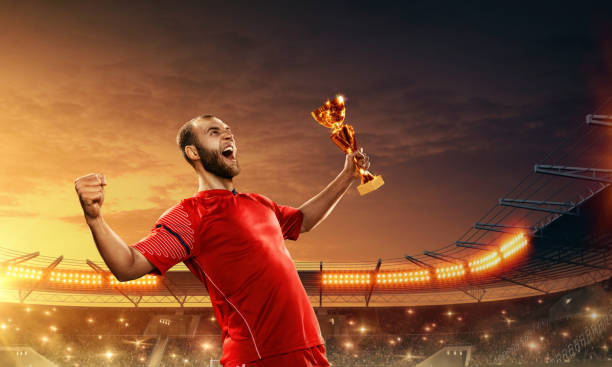 istock Soccer player celebrates victory and holds a trophy 1158619680