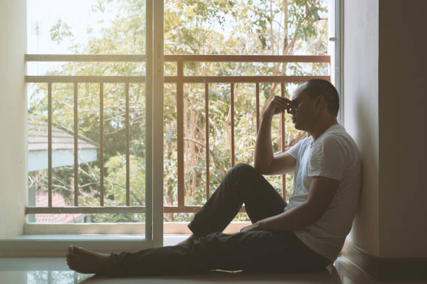 istock depressed man sitting in dark room 1158619808