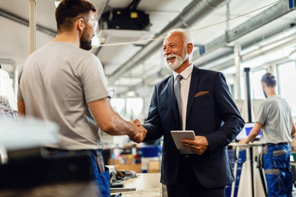 istock Happy mature manager greeting a worker while visiting industrial facility, 1158619918