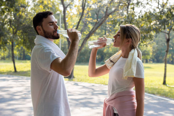 istock Young couples who drink water after exercising in the park. 1158620692