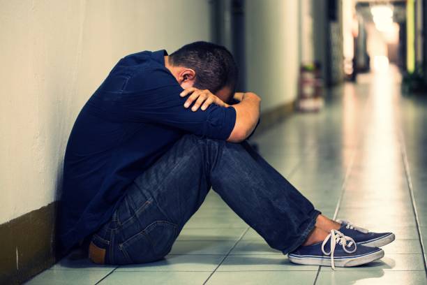 istock depressed man sitting in dark room 1158621251