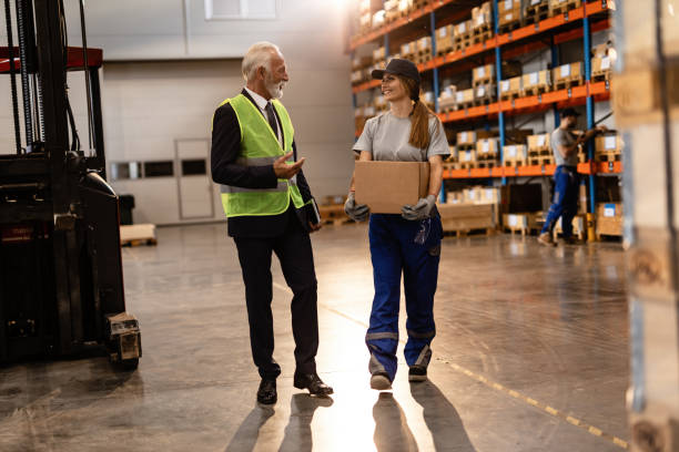 istock Happy senior businessman communicating with female distribution warehouse worker. 1158622120