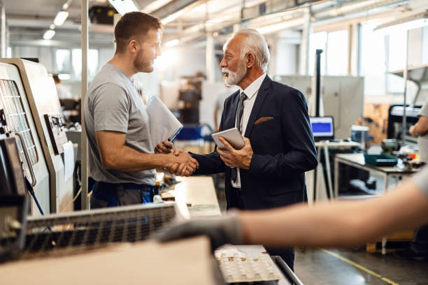 istock Young manual worker greeting senior manager in industrial building. 1158622206