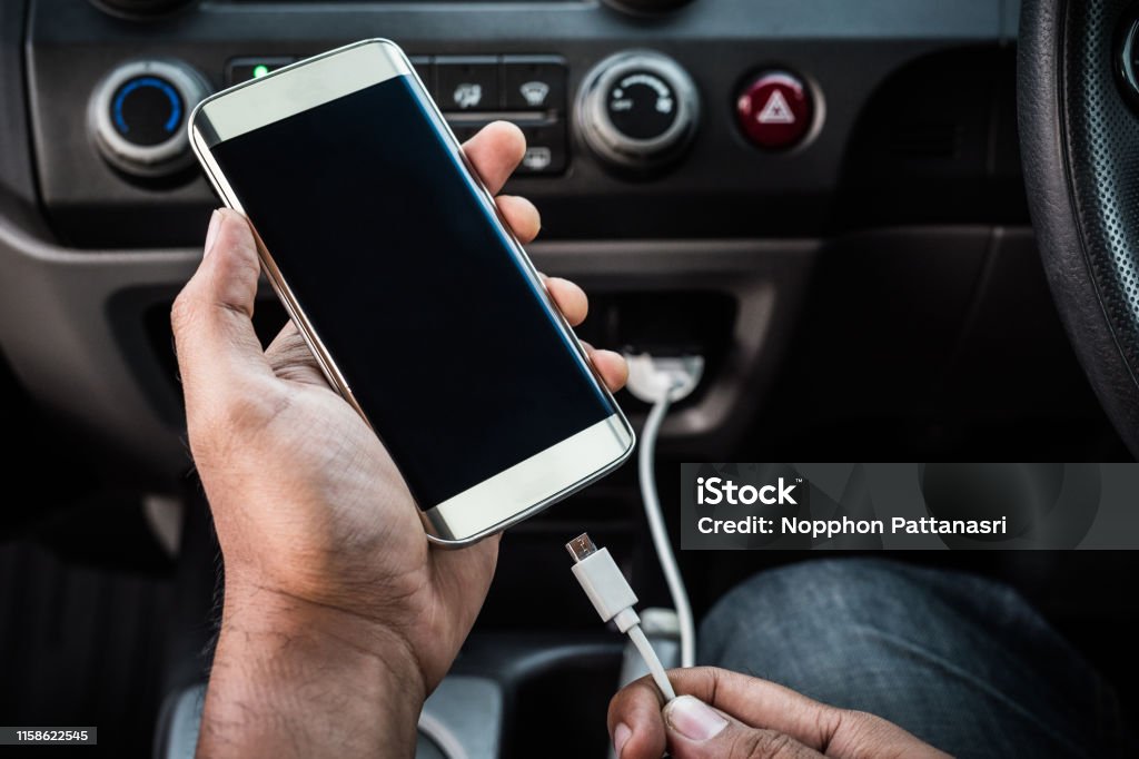 Charging smart phones in the car Car Stock Photo