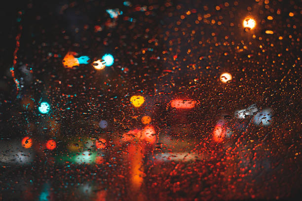 istock Abstract blurred traffic in raining at night. Rain drops on car glass. 1158622709
