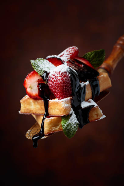istock Belgian waffles with strawberries, mint and chocolate sauce. 1158623384