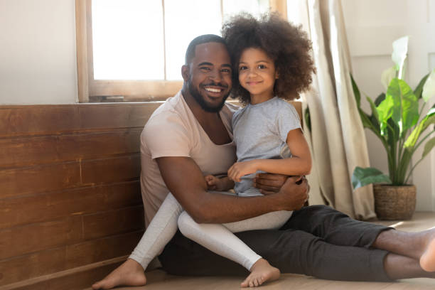 istock Happy african dad and kid daughter bonding looking at camera 1158624956