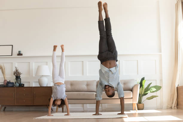 active african kid girl copy father doing handstand at home - family african ethnicity black african descent imagens e fotografias de stock