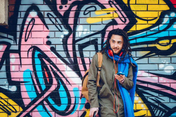 Young man with dreadlocks enjoys music