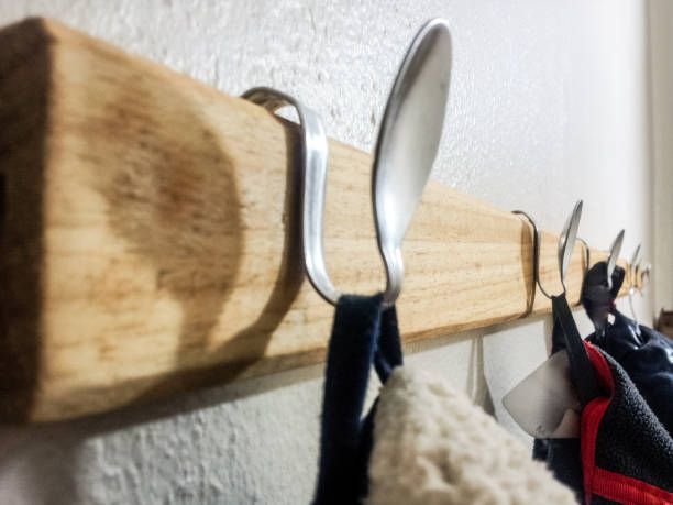 Upcycling coat hanger with spoons on wall stock photo