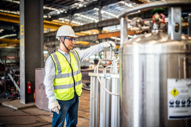 trabajador asiático operando un tanque de gas en una fábrica - manejar una máquina fotos fotografías e imágenes de stock