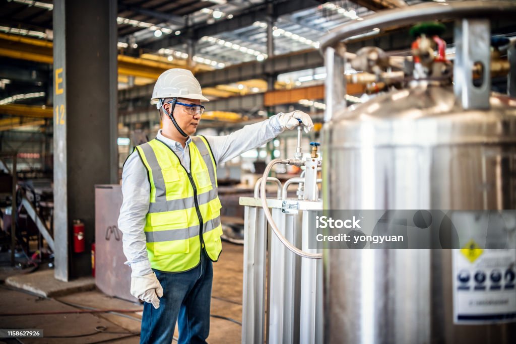 Asian worker operating a gas tank in a factory Asian worker operating a gas tank in a factory. Hydrogen Stock Photo