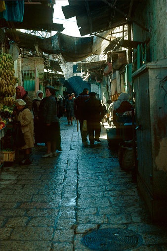 Jerusalem, Israel, 1976. Old town alley in Jerusalem with locals, shops, buildings and tourists.
