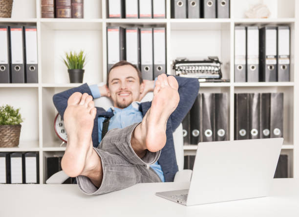 istock Handsome barefoot business man relaxing. Focus on legs 1158629995
