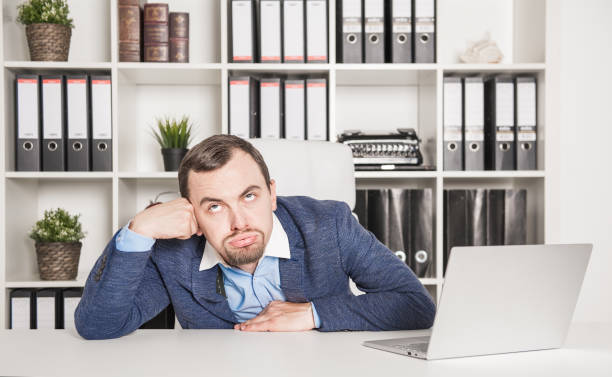 istock Bored young business man in office 1158630058