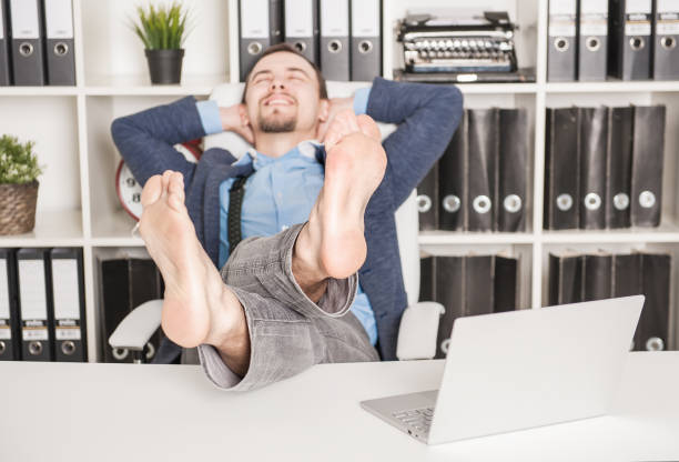 istock Handsome barefoot business man relaxing. Focus on legs 1158630648