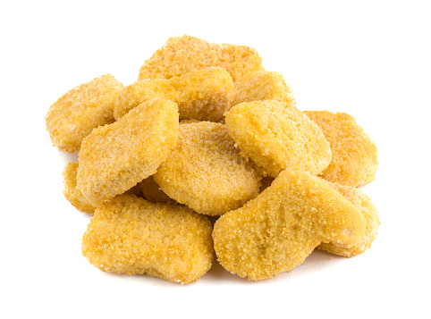 Frozen nuggets on a white background. Several chicken nuggets in breading close-up on a white background.