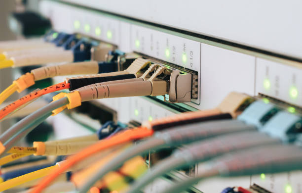 istock Telecommunications cables are connected to the main server. Internet wires are connected to the central router interfaces. There are many optical patchcards in the data center server room. Selective focus 1158632354