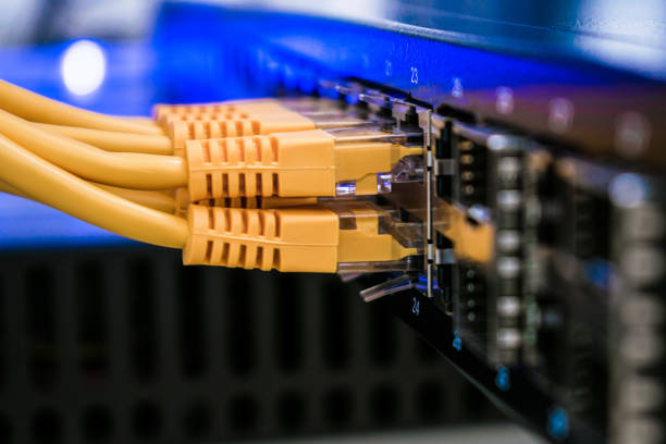 istock Utp wires are in the office router close-up. Internet cable is in the datacenter server room. Several yellow network wires are connected to the switching hub ports. Information technology concept. 1158632478