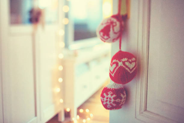Self made knitted red Christmas bauble on the door handle