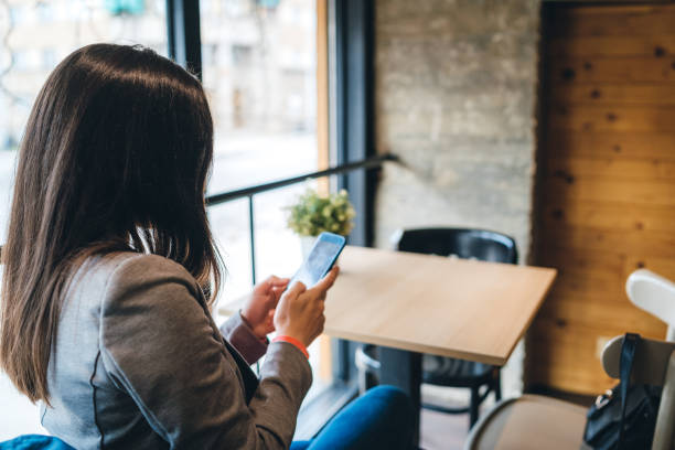 istock Woman using phone in cafe 1158633214