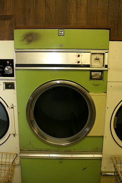 Coin Laundry Dryer straight from the 70s - green coin dryer beneath fashionable paneling tumble dryer stock pictures, royalty-free photos & images