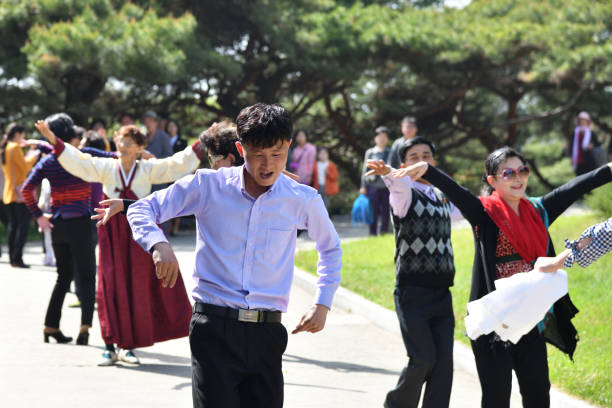 Pyongyang, North Korea - May 1, 2019: People relax and dance to music in the public park of city