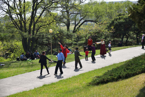 Pyongyang, North Korea - May 1, 2019: People relax and dance to music in the public park of city