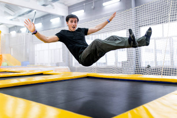 A young man trampolining in fly park A young man trampolining in fly park trampoline stock pictures, royalty-free photos & images