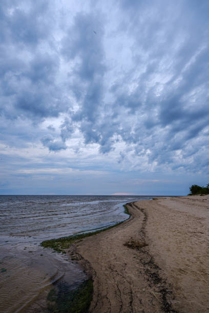 istock dramatic colorful clouds over sandy beach at the sea with blue sky 1158642483