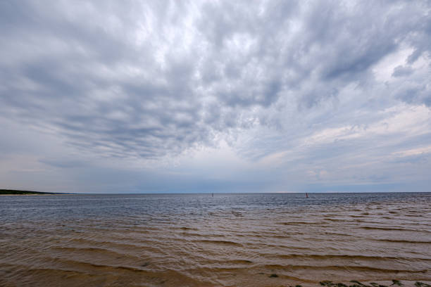 istock dramatic colorful clouds over sandy beach at the sea with blue sky 1158642484