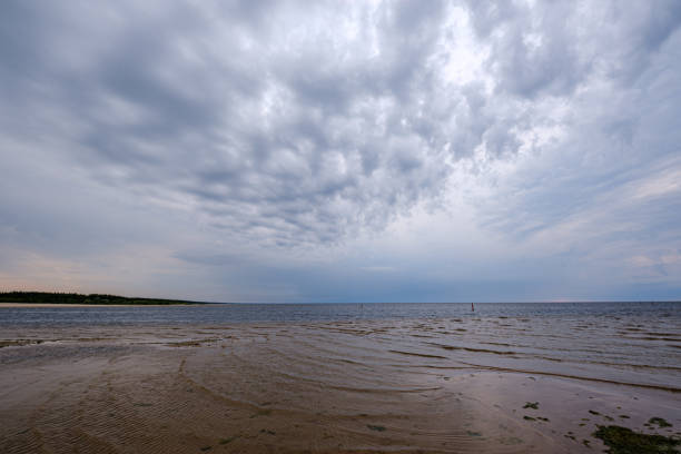 istock dramatic colorful clouds over sandy beach at the sea with blue sky 1158642515